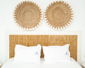 a bedroom with two white pillows and two hats on the wall at Blue Harbour Boutique in Ayia Napa