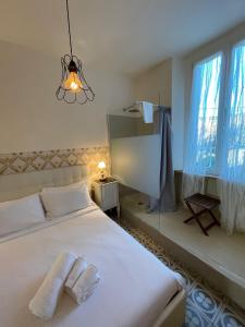 a bedroom with a white bed and a chandelier at Locanda Garzelli in Quercianella