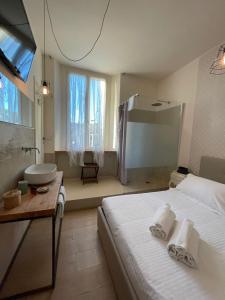 a bedroom with a bed and a bathroom with a sink at Locanda Garzelli in Quercianella