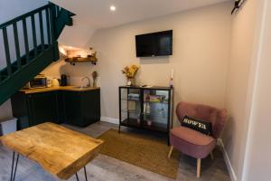 uma sala de estar com uma cadeira e uma mesa em Stay Barrow Blueway - The Stables em Monasterevin