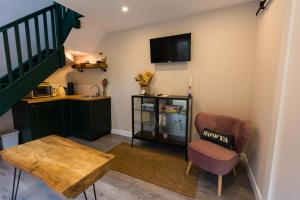 a living room with a chair and a table at Stay Barrow Blueway - The Stables in Monasterevin
