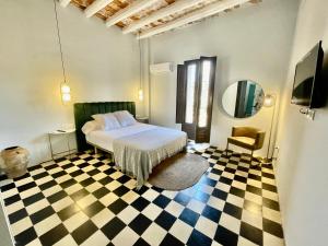 ein Schlafzimmer mit einem Bett und einem Schachbrettboden in der Unterkunft La Casa del Carrer Major in Santa Magdalena de Pulpis + 13 Fotos