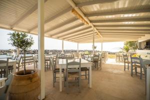 een restaurant met tafels en stoelen en uitzicht op de oceaan bij Mylos Seaside Experience in Frangokastello