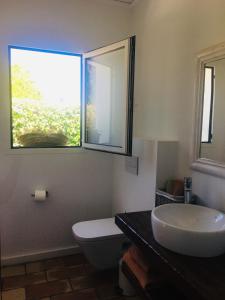 baño con lavabo y aseo y ventana en Habitación con jardín y terraza en el Tosalet, en Jávea