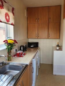 una cucina con lavandino e piano di lavoro di Polly's Place - A lovely 3 bed first floor flat, near to beach with free parking a Clacton-on-Sea