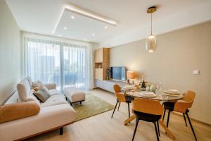 een woonkamer met een bank en een tafel met stoelen bij MF Coral 64 Premium Apartment in Siófok