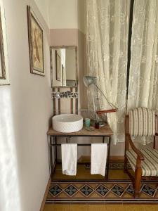 a bathroom with a sink and a chair and a mirror at Locanda Garzelli in Quercianella