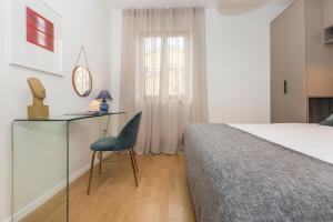 a bedroom with a bed and a desk and a chair at Apartments Agava in Rabac