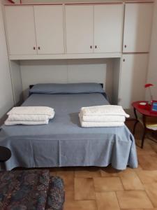 1 dormitorio con 1 cama azul y armarios blancos en Monolocale al BlueMarine, en Riposto