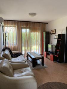 a living room with two couches and a tv at Апартамент Silver Star in Sozopol