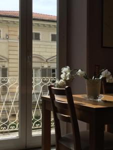 einen Tisch mit einer Vase aus Blumen und einem Fenster in der Unterkunft La Casa di Chicca & Paolo in La Spezia