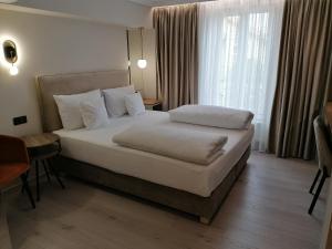 um quarto de hotel com uma cama grande e uma janela em Casa La Fayette em Timisoara