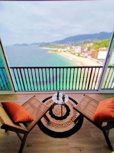 a balcony with a table and chairs and a beach at Piso El Acantilado in Bueu