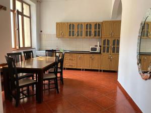 a kitchen with wooden cabinets and a table and chairs at M & I Apartment 1 in Târgu-Mureş