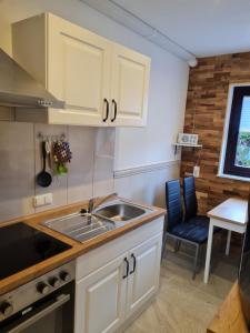 a kitchen with white cabinets and a sink at Ferienwohnung am Rüstersieler Hof in Wilhelmshaven