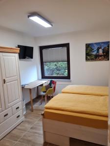 a bedroom with a bed and a desk in it at Ferienwohnung am Rüstersieler Hof in Wilhelmshaven