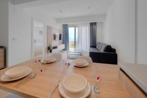 a dining room table with plates and wine glasses at Horizon-One bedroom apartment with pool Jane in Becici