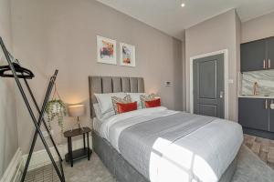 a bedroom with a large bed with red pillows at Guest Homes - Shaw Street Apartment in Worcester
