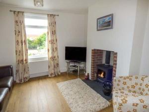 a living room with a couch and a fireplace at Pebble Cottage in Saltburn-by-the-Sea