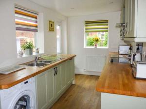 a kitchen with a sink and a washing machine at Pebble Cottage in Saltburn-by-the-Sea