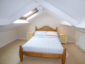 a bedroom with a wooden bed in a attic at Pebble Cottage in Saltburn-by-the-Sea