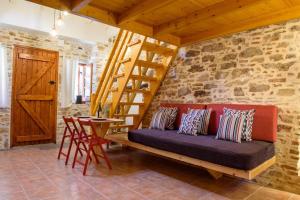 a living room with a couch and a wooden staircase at Lavrio stone house 5 min from the centre/port in Lávrion