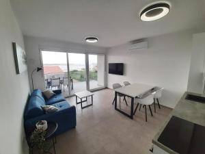 a living room with a blue couch and a table at Apartments Anda Nin in Nin