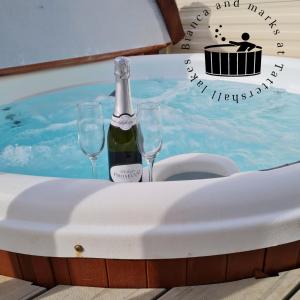 una mesa con una botella de champán y dos copas de vino en Bianca and marks 8 berth Caravan with Hot tub, en Tattershall