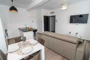 a living room with a couch and a table at Brand new 2 BR Gambetta Fully Renovated 2021- 5 mns Palais by Olam Properties in Cannes