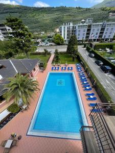 an overhead view of a swimming pool with blue lounge chairs at SunLake Hotel in Riva del Garda