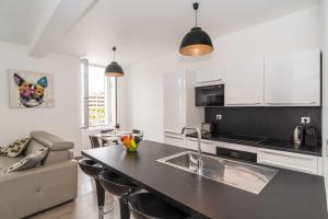 a kitchen and living room with a black counter top at Brand new 2 BR Gambetta Fully Renovated 2021- 5 mns Palais by Olam Properties in Cannes
