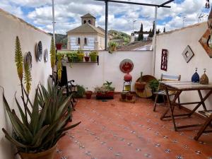 un patio con mesa y macetas en un edificio en La casa del Sur, en Granada
