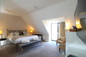 a bedroom with a large bed and a chair at St Mary's Inn in Morpeth