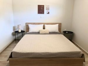 ενtreé guest house near Palamidi Castle في نافبليو: غرفة نوم بسرير كبير وطاولتين