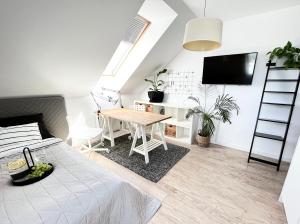 een woonkamer met een tafel en een televisie bij Ach to tu Apartament in Ostróda