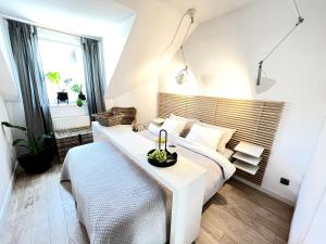 een slaapkamer met een wit bed en een tafel bij Ach to tu Apartament in Ostróda +23 foto's