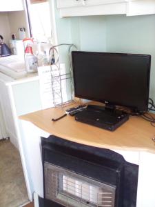 a computer monitor sitting on a desk in a kitchen at River Views Dog friendly caravan 3 bedrooms in Rye