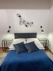 sypialnia z niebieskim łóżkiem z dwoma stołami w obiekcie Willa nad rzeką w Kłodzku
