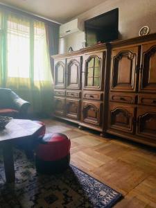 a living room with a large wooden entertainment center at Homestay Happiness in Tbilisi City