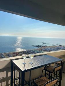 two wine glasses sitting on a table on a balcony at Beach front - sea and sunset views in Póvoa de Varzim