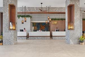 a lobby of a hotel with reception desks at Hotel Riu Baobab - All Inclusive in Pointe-Sarène