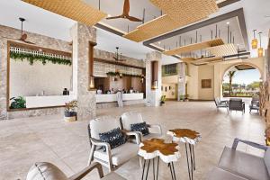 a lobby of a resort with chairs and a bar at Hotel Riu Baobab - All Inclusive in Pointe-Sarène