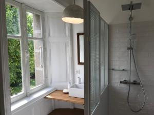 Piégut-PluviersにあるMaison Mercrediのシャワーと洗面台と窓のあるバスルーム