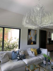 a living room with a white couch and a chandelier at Luxury condo in cap cana in Punta Cana