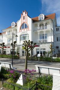 een groot wit gebouw met banken ervoor bij Appartementhaus Bellevue Binz in Binz