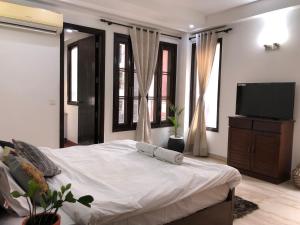 a bedroom with a bed and a flat screen tv at Avatar Living @Safdarjung Enclave in New Delhi