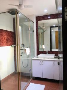 a bathroom with a shower and a white sink at Avatar Living @Safdarjung Enclave in New Delhi