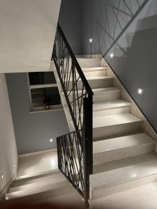 un escalier dans une maison avec un rail noir dans l'établissement Apartments Tanja, à Kaštela