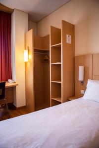 a bedroom with a bed and a desk and a closet at Ibis Kaunas Centre in Kaunas