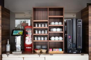 a kitchen with a coffee maker and a refrigerator at Ibis Kaunas Centre in Kaunas